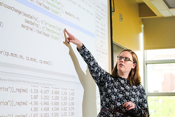 Instructor pointing to screen with code